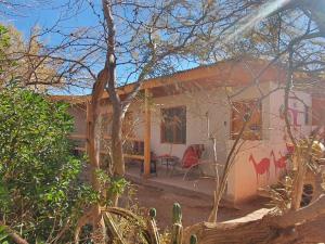 a house with a red chair in front of it at Hostal Candelaria in San Pedro de Atacama