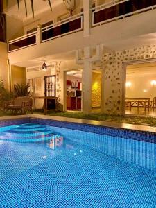 a large swimming pool in the middle of a house at L'Oasis Guesthouse in Cotonou