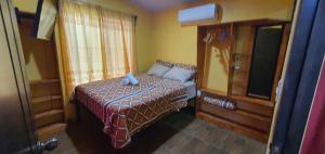 Un dormitorio pequeño con una cama y una ventana. en Tío King Hospedaje Turístico, en Uvita