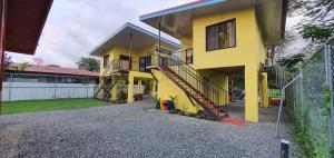 una casa amarilla con una escalera delante de ella en Tío King Hospedaje Turístico, en Uvita