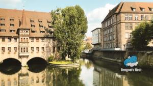 ein Fluss mitten in einer Stadt mit Gebäuden in der Unterkunft Dragon’s Nest: Cozy & modern attic loft Nuremberg in Schwaig bei Nürnberg
