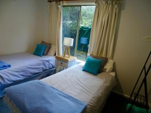 two beds in a room with a window at Beachwalk Cottage in Sorrento