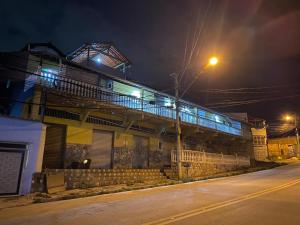 サンタ・ルジアにあるPousada & Hostel Belo Valeの夜間の路上バルコニー付きの建物