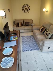 uma sala de estar com um sofá e uma mesa em Porto Pim Beach House em Horta