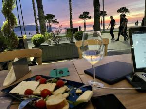 a table with a plate of cheese and a glass of wine at ELMAR HOTEL in Vlorë