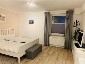 a bedroom with a white bed and a window at Altstadt Ankerplatz in Emden