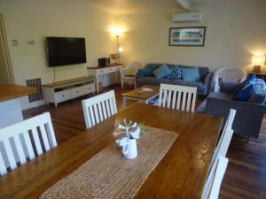 Beachwalk Cottage في سورينتو: غرفة معيشة مع طاولة وأريكة