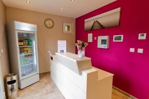 a store with a pink wall and a cash register at Hôtel Les Petits Oreillers in Saint-Martin-dʼArdèche