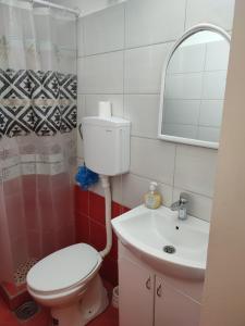 a bathroom with a toilet and a sink and a mirror at Apartman UNA in Kruševac +15 photos