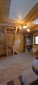 a large room with a fireplace and wooden ceilings at Domek Pod Tylką in Grywałd