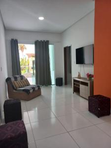 a living room with a couch and a flat screen tv at Casa milagres in São Miguel dos Milagres
