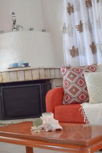 sala de estar con sofá rojo y TV en Kalivia House - Entire Home, en Gythio