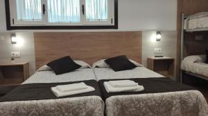 Un dormitorio con una cama grande con dos toallas encima. en Hostel Boente, en Boente
