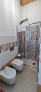 a bathroom with a toilet and a sink and a shower at Fèdeli House Pool in Noto
