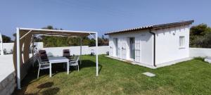 a backyard with a table and chairs under a tent at Fèdeli House Pool in Noto
