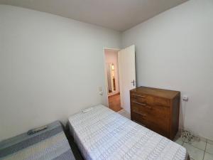 ヴィトーリアにあるApto com dois quartos no bairro de Jardim Camburiのベッドルーム1室(ベッド2台、木製ドレッサー付)