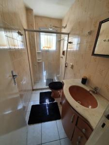 uma casa de banho com um lavatório, um chuveiro e um WC. em Apto com dois quartos no bairro de Jardim Camburi em Vitória
