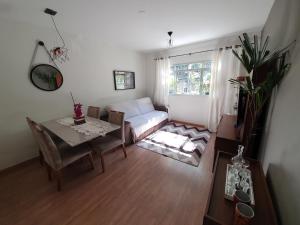 ヴィトーリアにあるApto com dois quartos no bairro de Jardim Camburiのリビングルーム(テーブル、ソファ付)