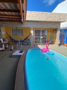 伊塔馬拉卡的住宿－Casa De Praia em Itamaracá，水中一个粉红色天鹅的游泳池