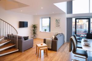a living room with two couches and a table at CITY CENTRE APARTMENT with Free Secure Underground Parking in Glasgow
