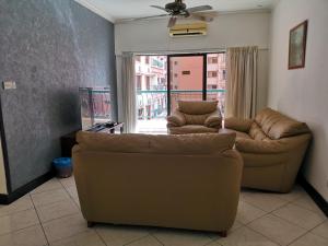 a living room with two couches and a large window at Marina Court KK City Homestay in Kota Kinabalu