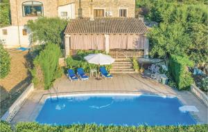 an overhead view of a swimming pool with two chairs and an umbrella at Amazing Apartment In Selva With 1 Bedrooms, Wifi And Outdoor Swimming Pool in El Port de la Selva