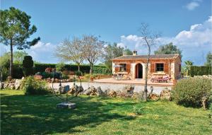 a small house in a garden with a stone wall at Awesome Home In Biniali With Wifi in Biniali +19 photos
