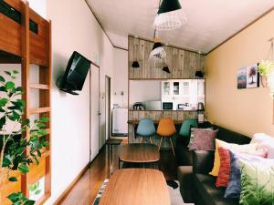 ein Wohnzimmer mit Sofa und Tisch in der Unterkunft 恩納村名嘉真フォレストヴィラ12時チェックアウト可ダブルベッド2台と2段ベッドとユニットバス2室 in Onna