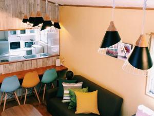 ein Wohnzimmer mit einem grünen Sofa und Stühlen in der Unterkunft 恩納村名嘉真フォレストヴィラ12時チェックアウト可ダブルベッド2台と2段ベッドとユニットバス2室 in Onna + 33 Fotos