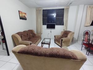 sala de estar con 2 sofás y TV en Departamento Melly, en Tarapoto