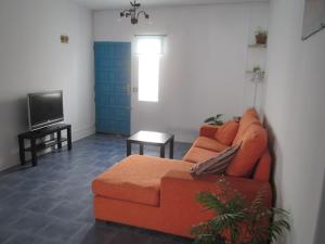 ティアスにあるCasa Sol y Mar Tiasのリビングルーム(オレンジ色のソファ、テレビ付)