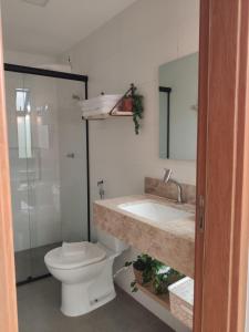 a bathroom with a toilet and a sink at Apto climatizado à beira-mar c/ piscina-Intermares in Cabedelo +8 photos
