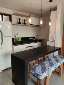 a kitchen with a black table and wooden chairs at Apto climatizado à beira-mar c/ piscina-Intermares in Cabedelo