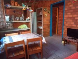 una sala da pranzo con tavolo e sedie e una cucina di Prive das Acacias a Porto De Galinhas