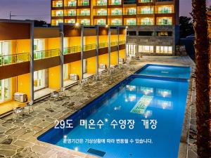 a hotel swimming pool in front of a building at Suandsu Resort in Jeju
