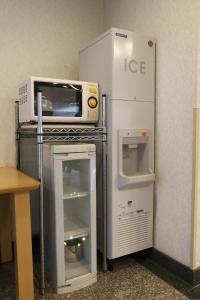 a microwave oven sitting on top of a refrigerator at Smile Hotel Takaoka Ekimae in Takaoka