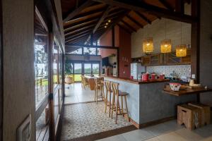 a kitchen with a counter and chairs in a room at Casa Vista da Pedra do Baú in Gonçalves