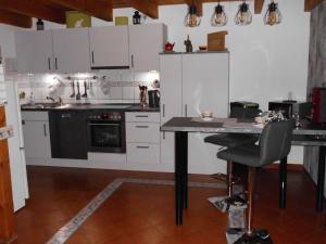 a kitchen with white cabinets and a table with a chair at Möwennest in Neuharlingersiel