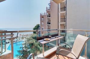 a balcony with a table and chair and a view at Beachfront Smart Homes by Marty's in Sunny Beach