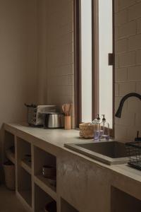um balcão de cozinha com um lavatório e um micro-ondas em Narrativ Lofts -Solario- Charming Historic Escape em Campeche