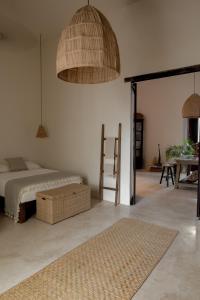 um quarto com uma cama, uma mesa e cadeiras em Narrativ Lofts -Solario- Charming Historic Escape em Campeche