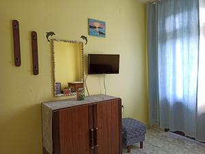 a room with a mirror and a dresser and a tv at Къща за гости Василеви Синеморец - Guest House Vasilevi Sinemorets in Sinemorets