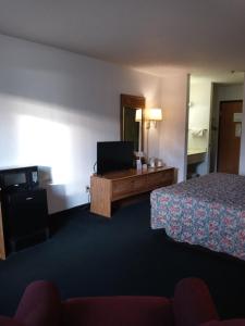 um quarto de hotel com uma cama e uma televisão de ecrã plano em New Martinsville Inn em New Martinsville