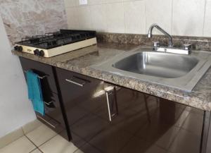 eine Küche mit einer Spüle und einem Herd in der Unterkunft Departamento privado zona de la UACH in Chihuahua