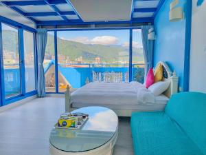 sypialnia z łóżkiem i dużym oknem w obiekcie Chiaohsi Mediterranean Spa B&B w mieście Jiaoxi