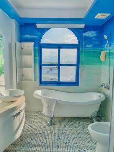 礁溪鄉的住宿－地中海溫泉民宿，蓝色的浴室设有浴缸和窗户。