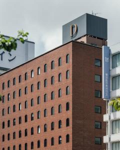 a red brick building with a sign on top of it at DDD HOTEL in Tokyo