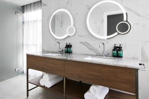 a bathroom with two sinks and two mirrors at Crowne Plaza Sydney Darling Harbour, an IHG Hotel in Sydney
