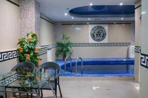 a swimming pool in a building with a table and chairs at Legend of Baikal in Listvyanka