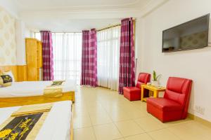una camera d'albergo con un letto e due sedie rosse di Khanh Hong Da Lat a Da Lat